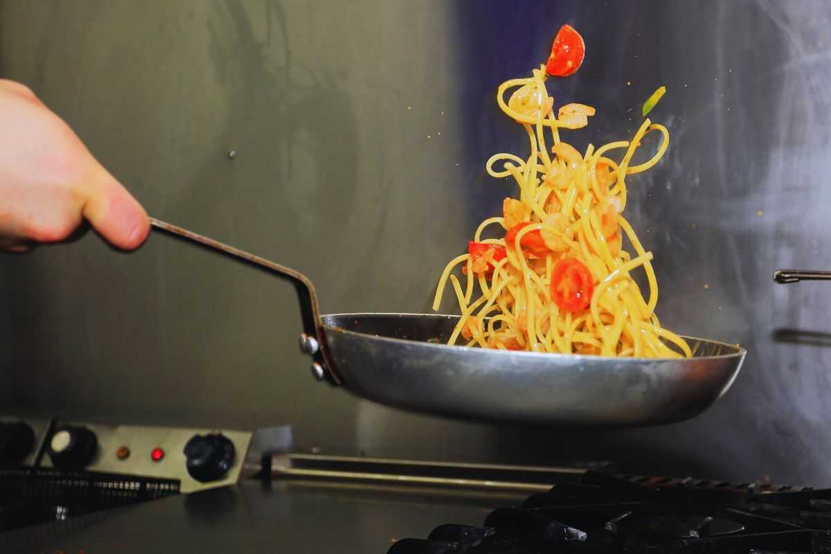 Chef che manteca piatto di pasta