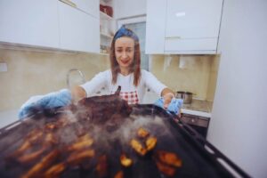 Donna che esce dal forno pietanze bruciate